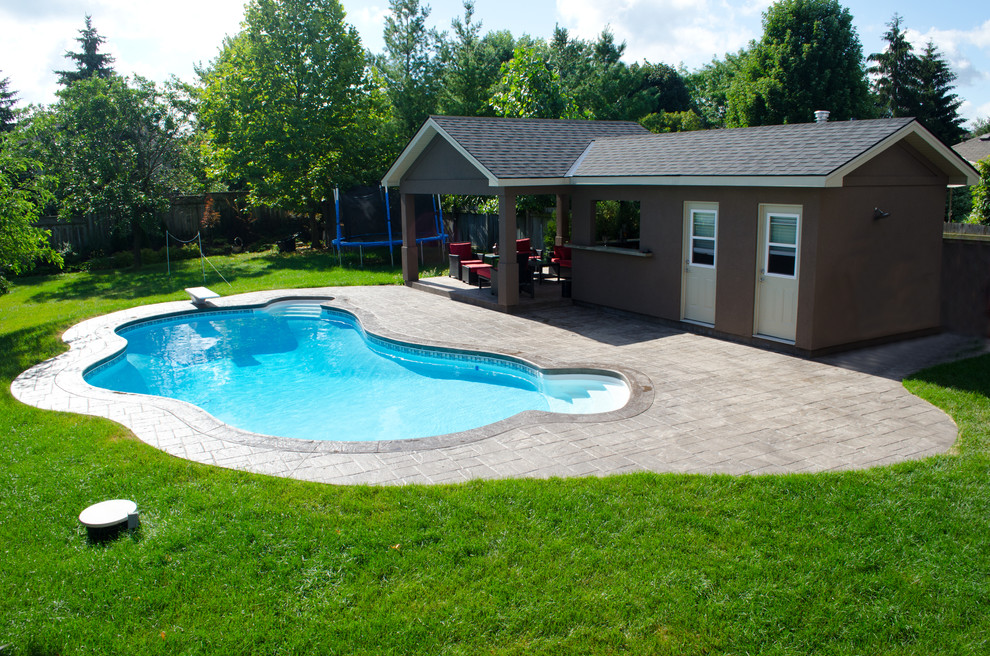 Esempio di una piscina chic personalizzata di medie dimensioni e dietro casa con pavimentazioni in cemento