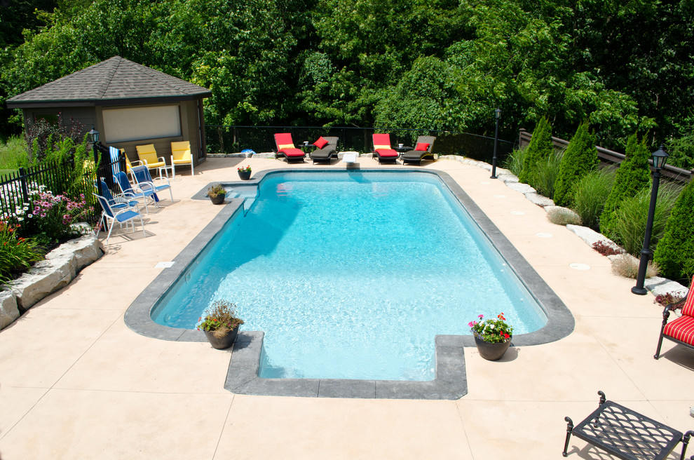 Immagine di una grande piscina monocorsia chic personalizzata dietro casa con una dépendance a bordo piscina e lastre di cemento