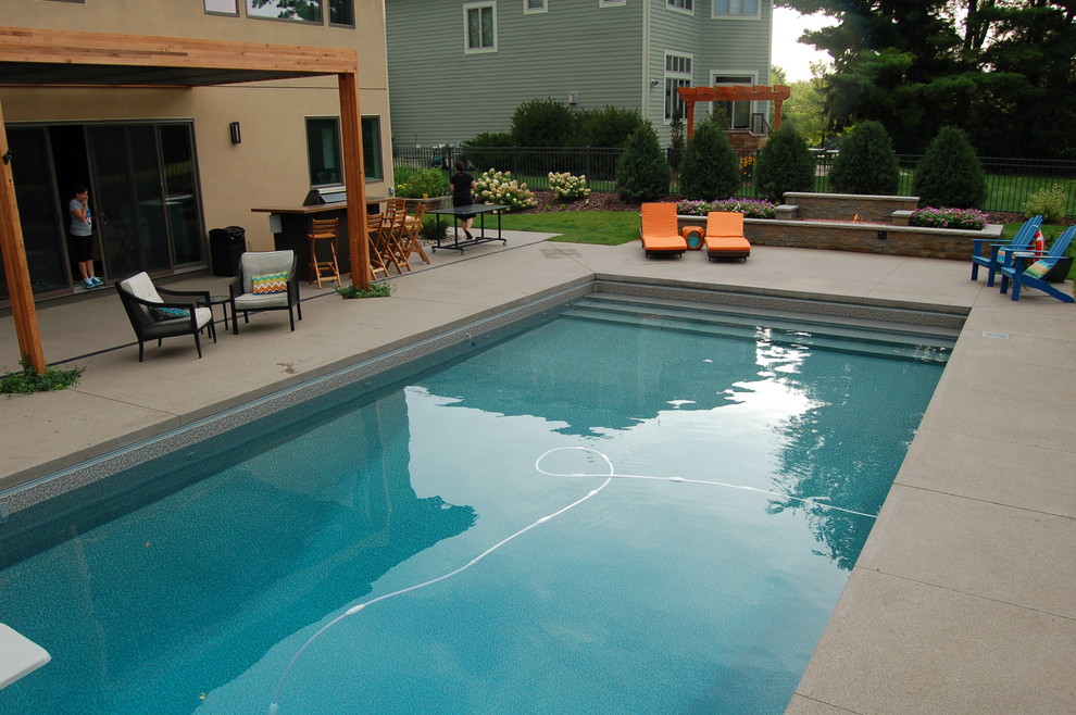 Inspiration för en liten funkis rektangulär pool på baksidan av huset, med betongplatta