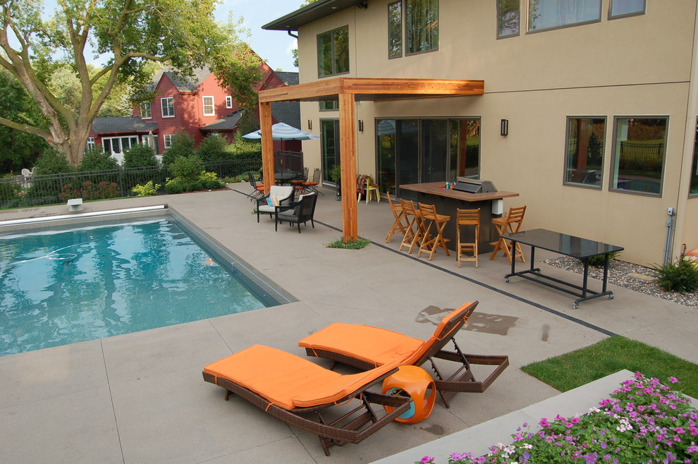 На фото: маленький прямоугольный бассейн на заднем дворе в современном стиле с покрытием из бетонных плит для на участке и в саду