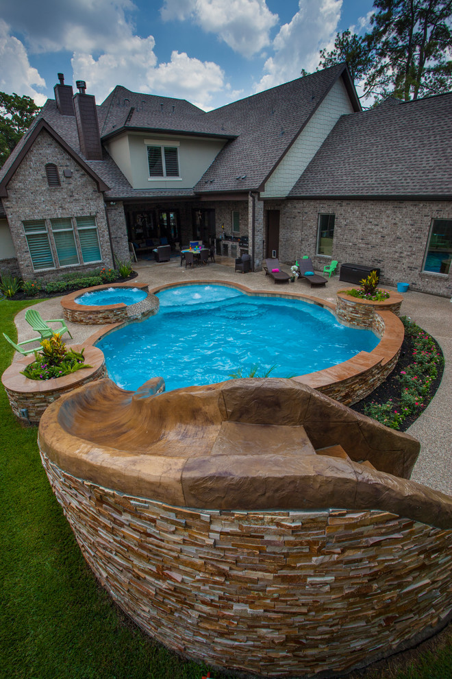 Aménagement d'une piscine naturelle et arrière moderne de taille moyenne et sur mesure avec un toboggan et une terrasse en bois.
