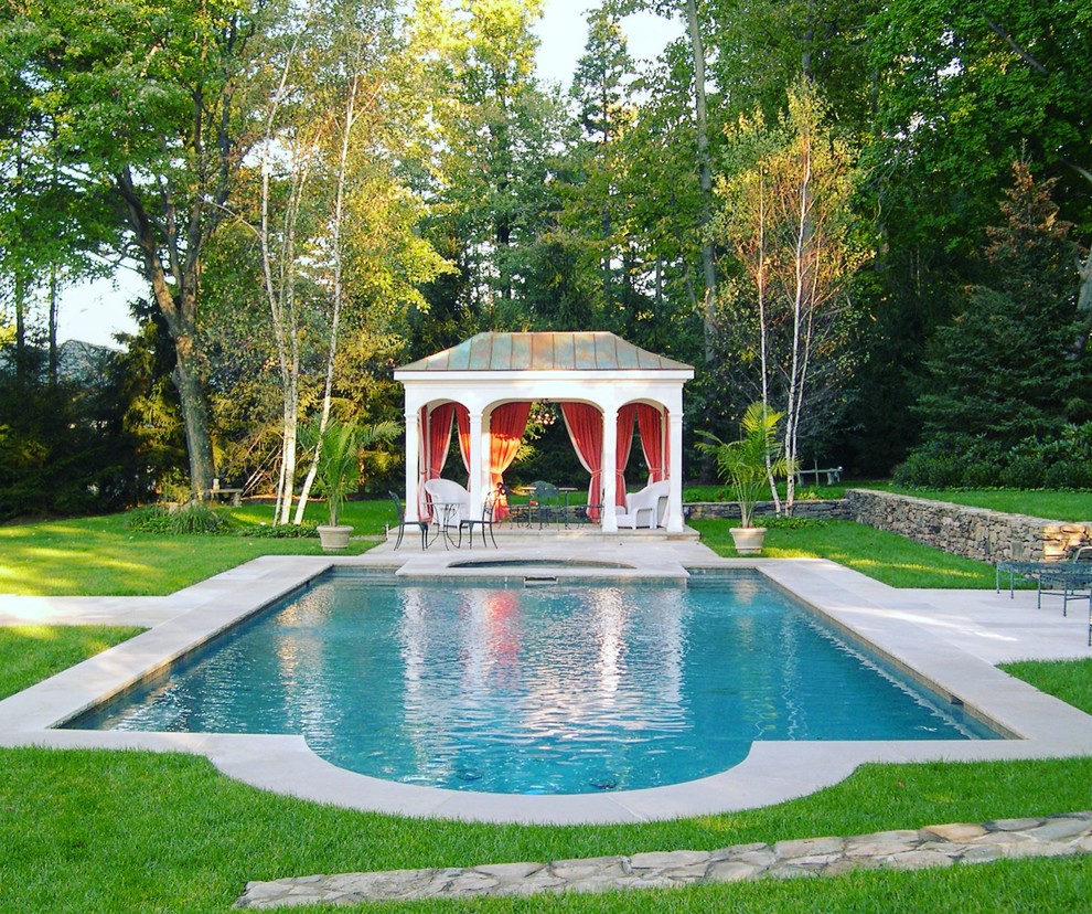 Ejemplo de piscinas y jacuzzis tradicionales de tamaño medio rectangulares en patio trasero con adoquines de hormigón