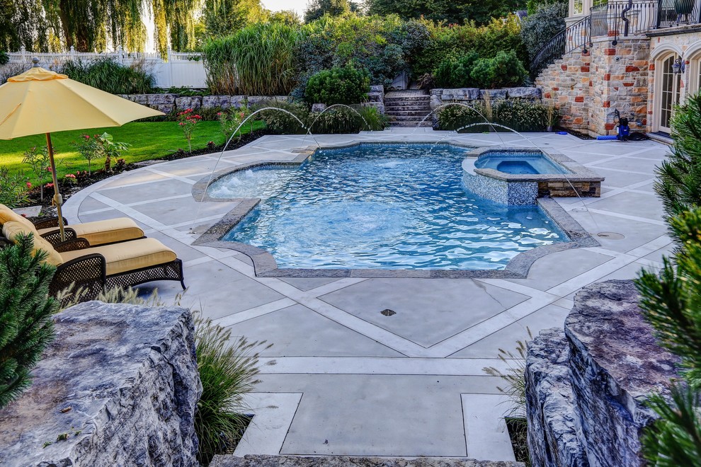 Стильный дизайн: прямоугольный бассейн среднего размера на заднем дворе в классическом стиле с джакузи и покрытием из декоративного бетона - последний тренд