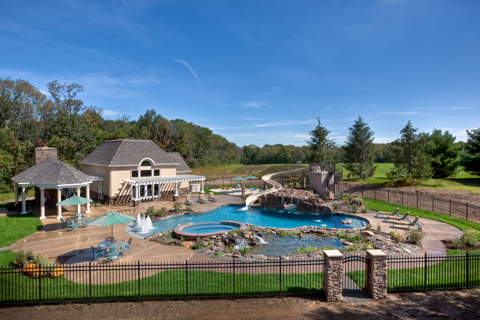 Esempio di un'ampia piscina naturale minimal personalizzata dietro casa con un acquascivolo e cemento stampato