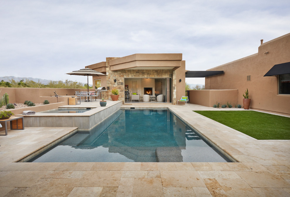 Ejemplo de casa de la piscina y piscina alargada de estilo americano rectangular en patio trasero con suelo de baldosas