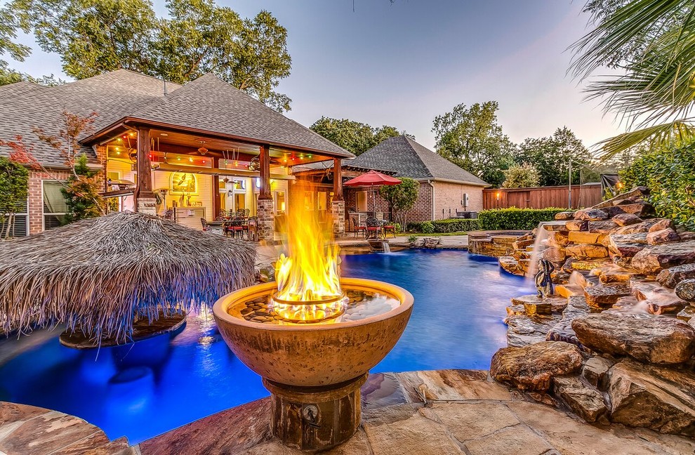 Idee per una piscina naturale tropicale personalizzata dietro casa e di medie dimensioni con fontane e pavimentazioni in pietra naturale
