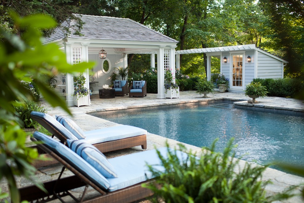 Idéer för en mellanstor klassisk pool på baksidan av huset, med poolhus och naturstensplattor