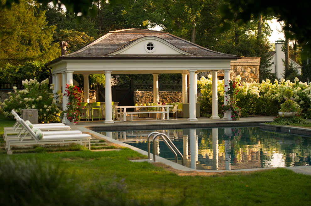 Ejemplo de casa de la piscina y piscina alargada tradicional de tamaño medio a medida en patio trasero con adoquines de piedra natural