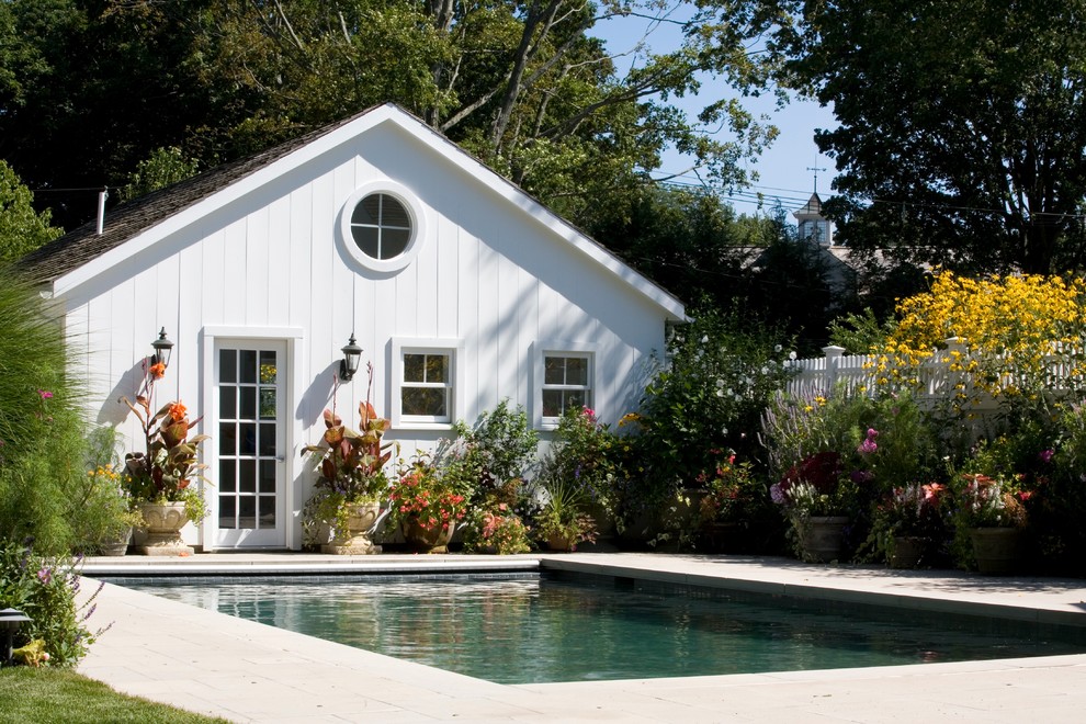 Inspiration för en mellanstor vintage rektangulär träningspool på baksidan av huset, med poolhus och naturstensplattor