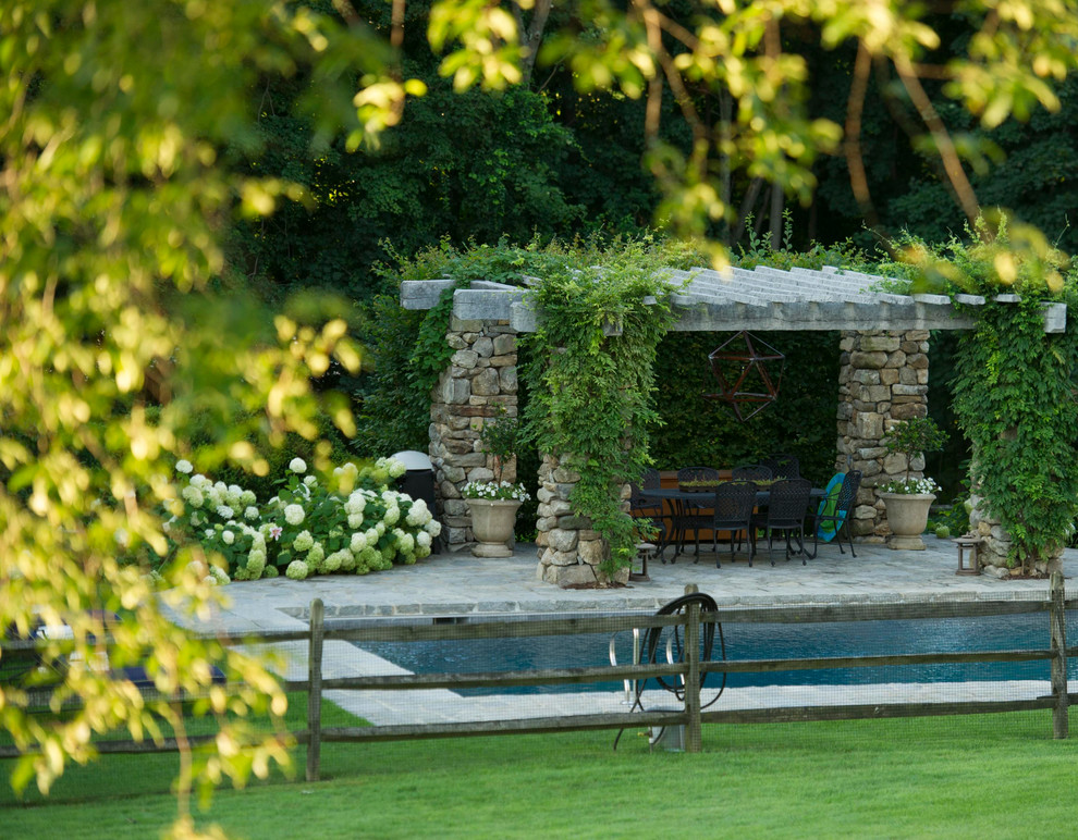 Imagen de casa de la piscina y piscina clásica de tamaño medio rectangular en patio trasero con adoquines de piedra natural