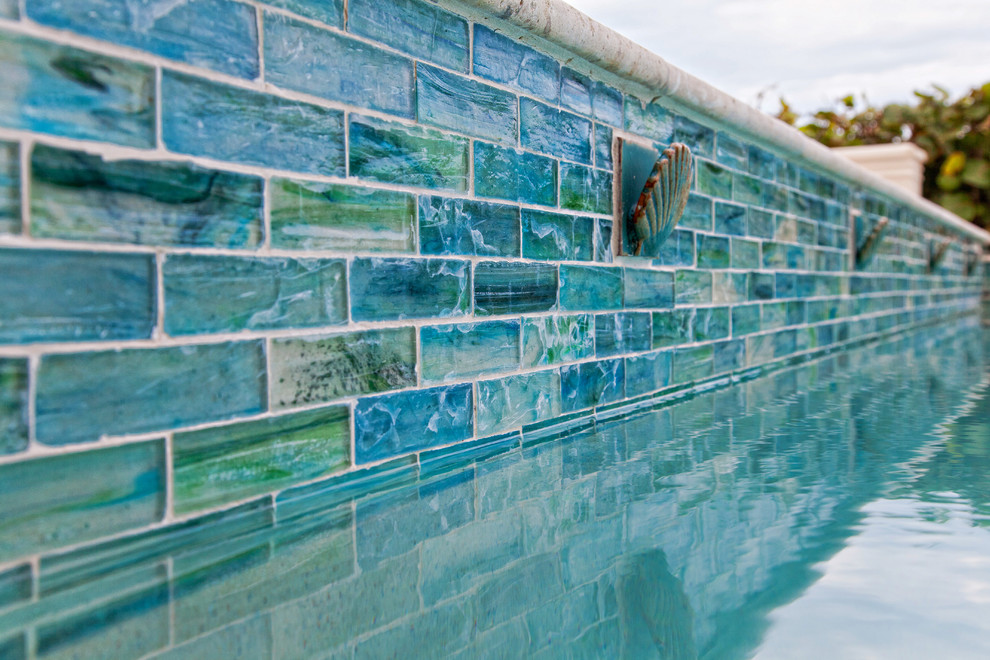 Esempio di una piscina minimal rettangolare di medie dimensioni e dietro casa con una vasca idromassaggio e piastrelle