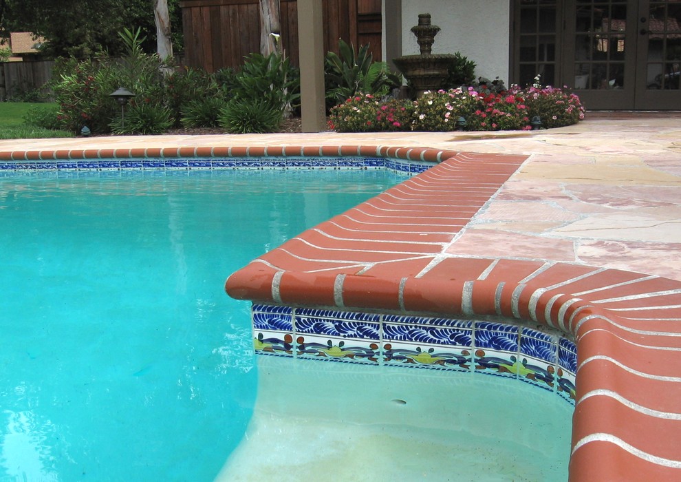 Ejemplo de piscina alargada mediterránea de tamaño medio rectangular en patio trasero con adoquines de piedra natural