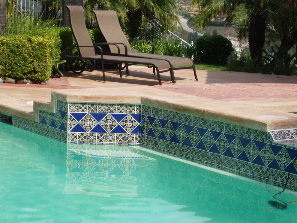 Modelo de piscinas y jacuzzis alargados mediterráneos grandes a medida en patio trasero con adoquines de piedra natural