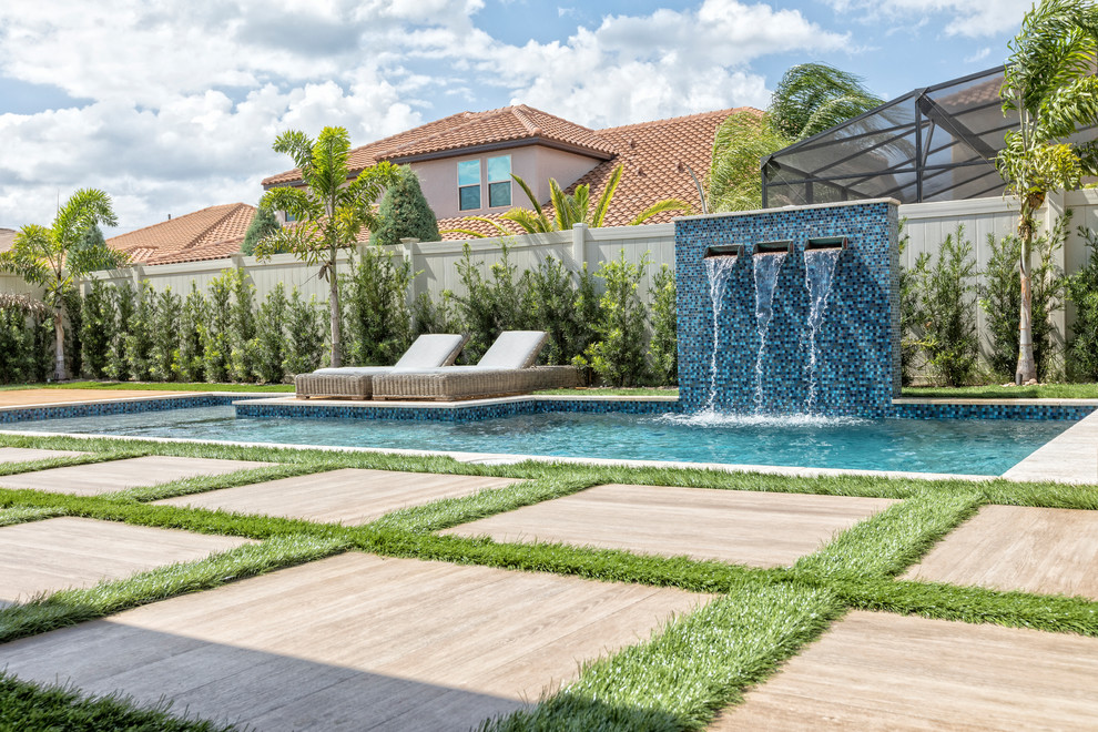 Diseño de piscina con fuente actual de tamaño medio a medida en patio trasero con suelo de baldosas