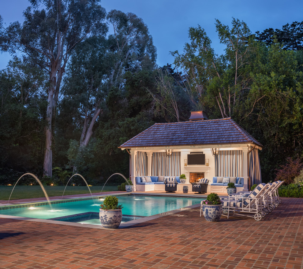 Imagen de casa de la piscina y piscina alargada tradicional grande rectangular en patio trasero con adoquines de ladrillo