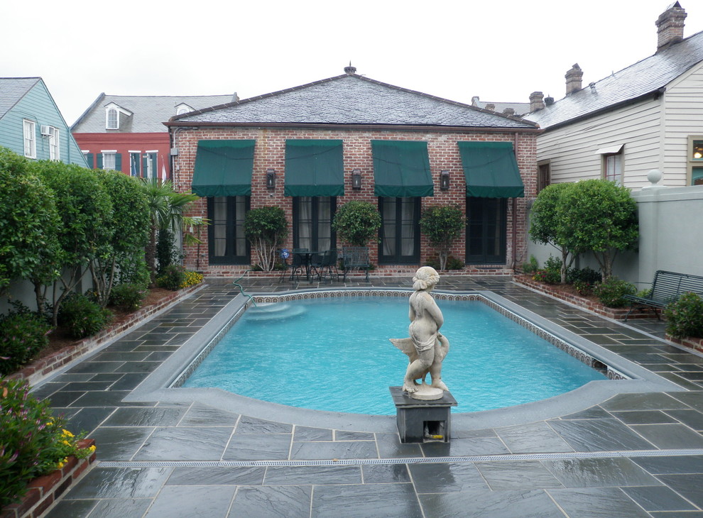 Idéer för en klassisk pool på baksidan av huset, med en fontän och naturstensplattor