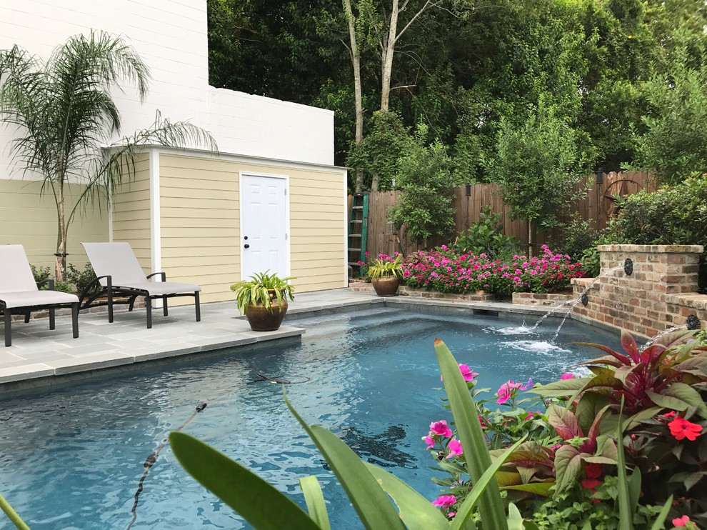 Exempel på en klassisk pool på baksidan av huset, med en fontän och naturstensplattor
