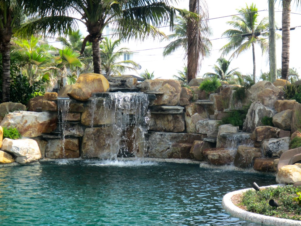 Foto di una piscina monocorsia tropicale personalizzata di medie dimensioni e dietro casa con fontane e pavimentazioni in pietra naturale