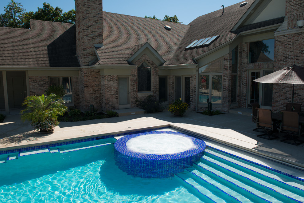 Photo of a modern back rectangular swimming pool in Cedar Rapids with stamped concrete.