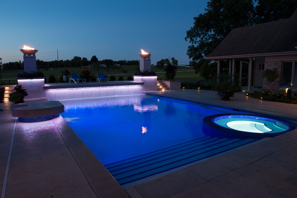 Diseño de piscina moderna rectangular en patio trasero con suelo de hormigón estampado