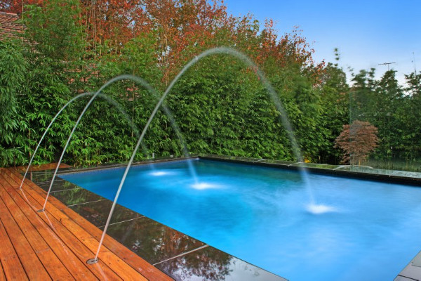 Modelo de piscina con fuente natural moderna pequeña a medida en patio con entablado