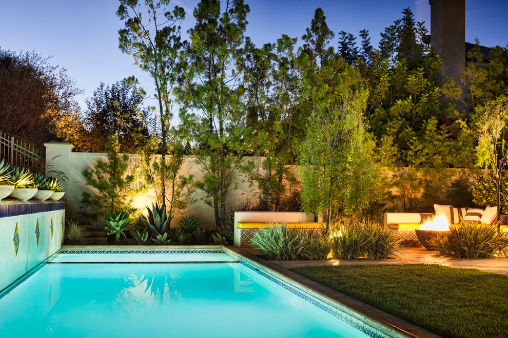 Mittelgroßer, Gefliester Mediterraner Schwimmteich hinter dem Haus in rechteckiger Form in Los Angeles