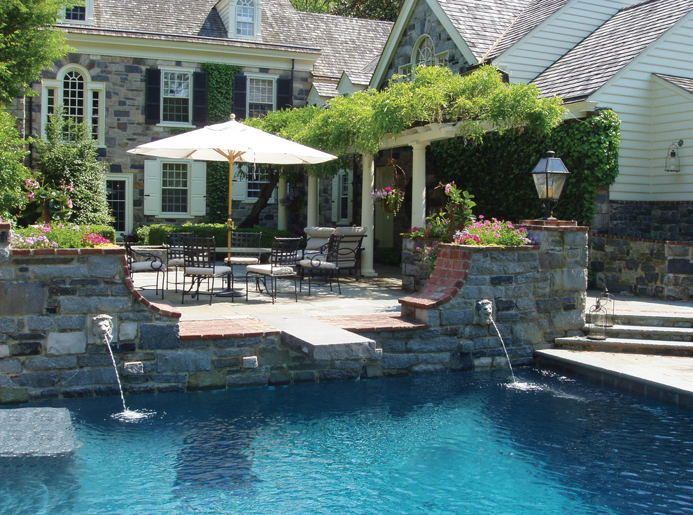 Large elegant backyard stone pool fountain photo in Philadelphia