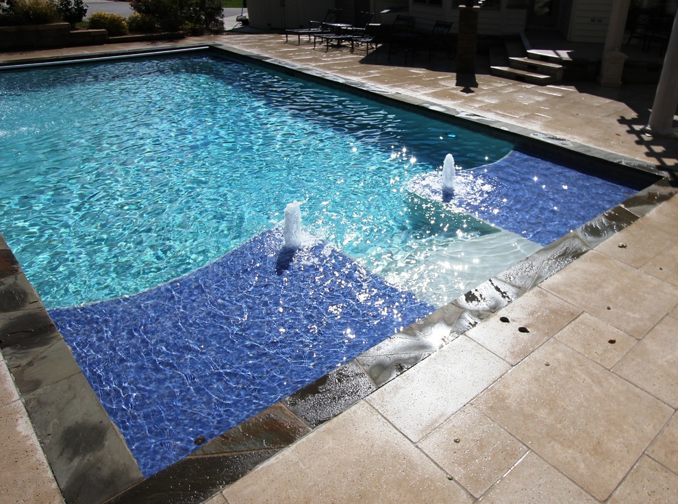 Pool with oversized tanning ledges and fire feature water slide