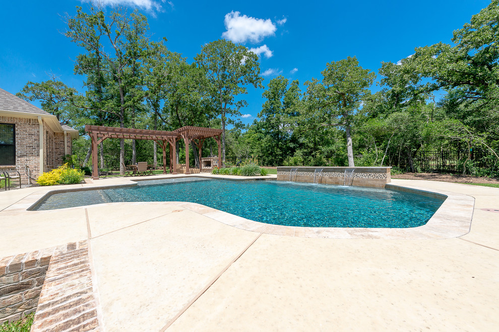 Esempio di una grande piscina naturale personalizzata dietro casa con cemento stampato