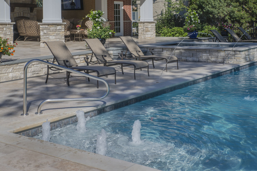 Imagen de piscinas y jacuzzis clásicos de tamaño medio rectangulares en patio trasero con adoquines de piedra natural