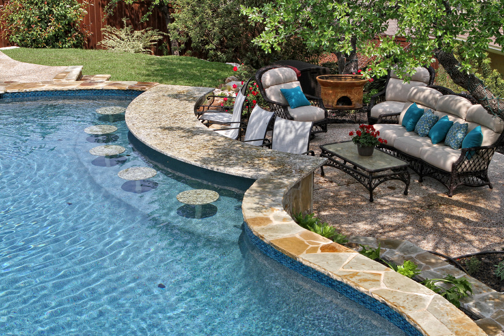Idee per una grande piscina naturale chic personalizzata dietro casa con pavimentazioni in pietra naturale e una vasca idromassaggio