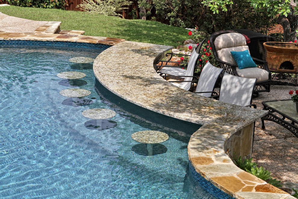 Modelo de piscinas y jacuzzis naturales tradicionales grandes a medida en patio trasero con adoquines de piedra natural