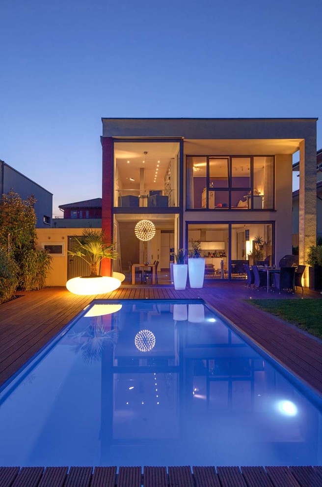 This is an example of a medium sized mediterranean side rectangular lengths swimming pool in Dusseldorf with decking.