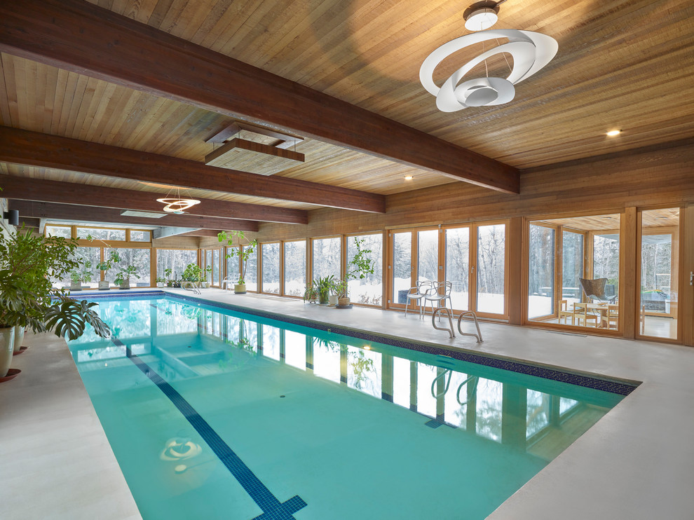Ejemplo de piscina alargada minimalista extra grande interior y rectangular con losas de hormigón