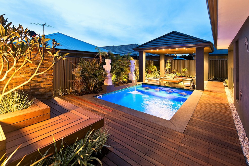 Cette photo montre un couloir de nage arrière exotique rectangle avec une terrasse en bois.