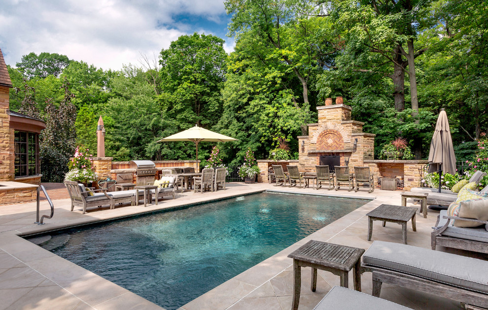 This is an example of a classic back rectangular swimming pool in Chicago with tiled flooring and a shelter.