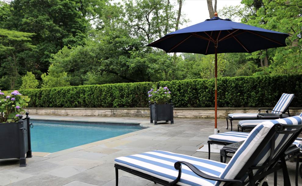 На фото: прямоугольный бассейн на заднем дворе в классическом стиле с покрытием из каменной брусчатки с
