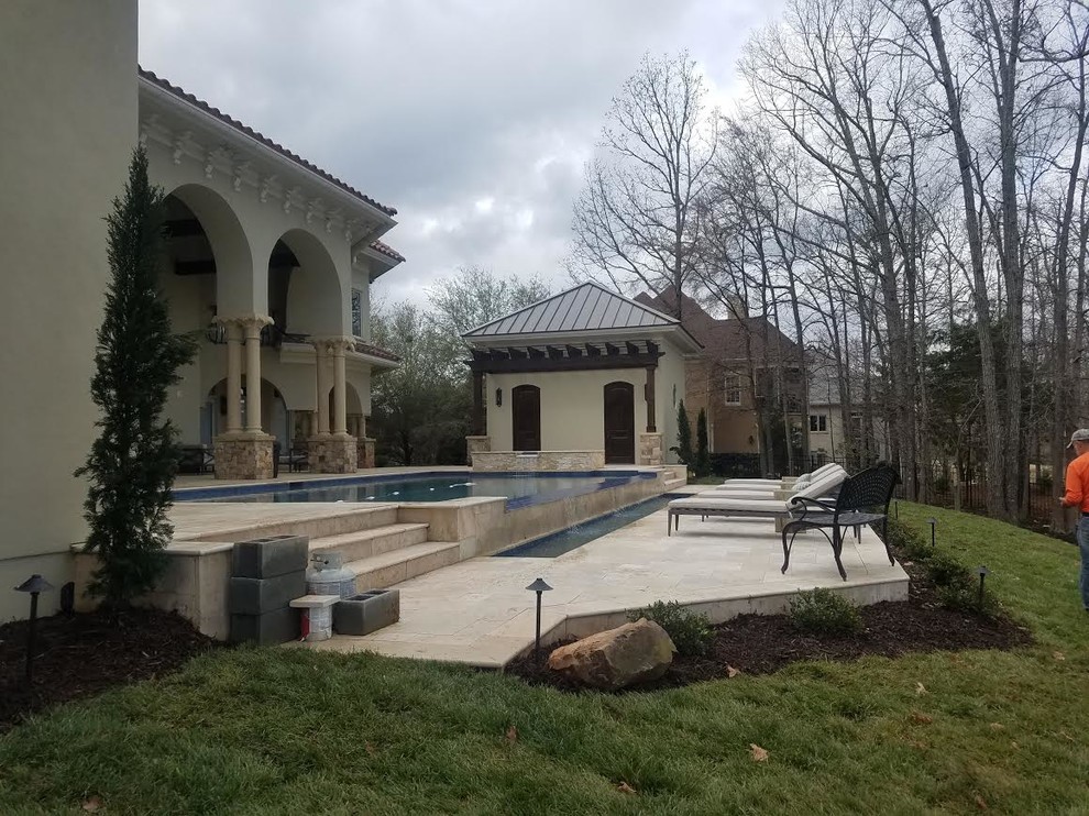 Example of a large trendy backyard concrete paver and rectangular infinity pool house design in Charlotte