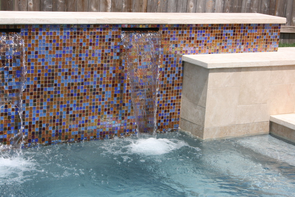 Diseño de piscina con fuente natural actual de tamaño medio a medida en patio trasero con adoquines de hormigón