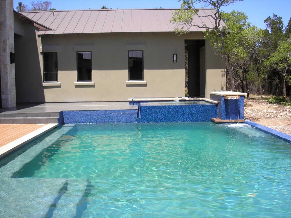 Cette photo montre une piscine naturelle et arrière tendance de taille moyenne et rectangle avec un point d'eau et des pavés en béton.