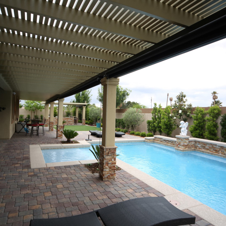 Foto de piscina clásica de tamaño medio a medida en patio trasero con adoquines de ladrillo
