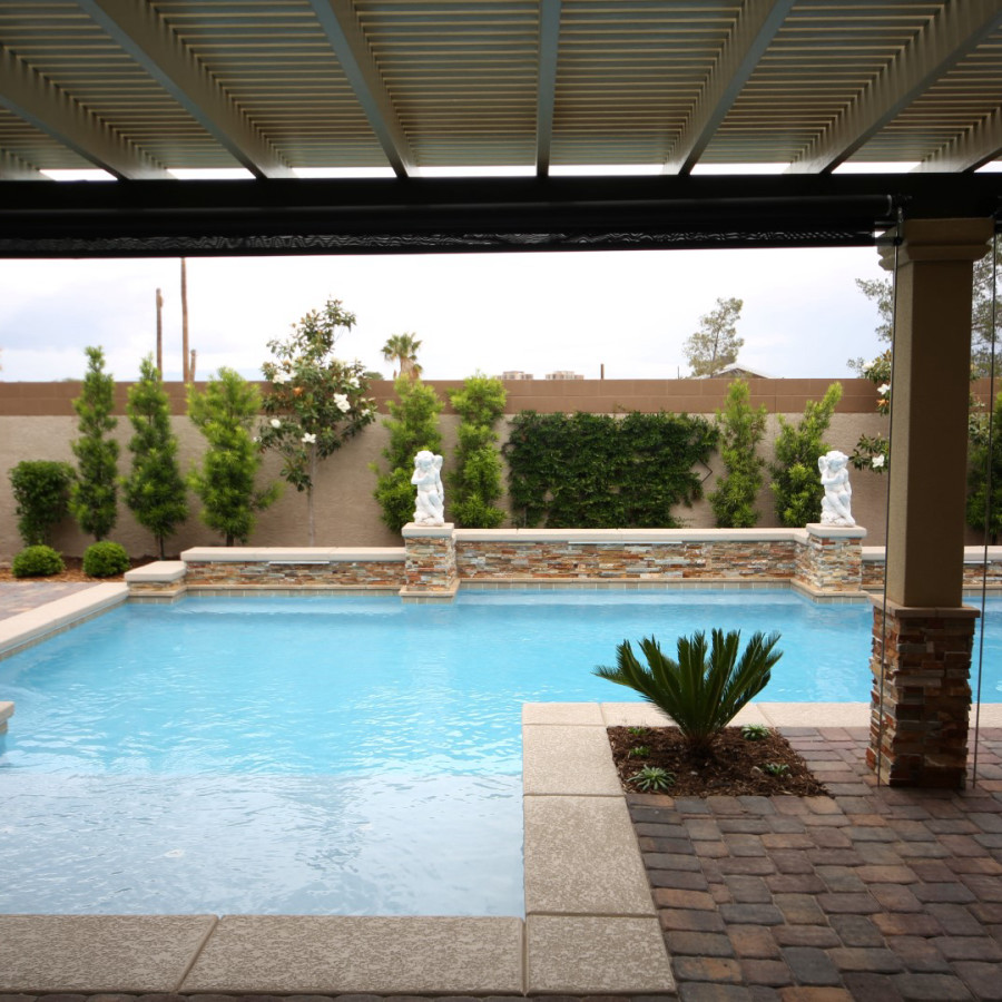Diseño de piscina alargada clásica de tamaño medio rectangular en patio trasero con adoquines de ladrillo