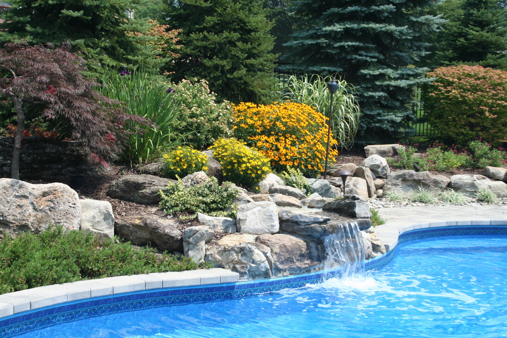 Foto di una piscina coperta american style personalizzata con fontane e pavimentazioni in cemento