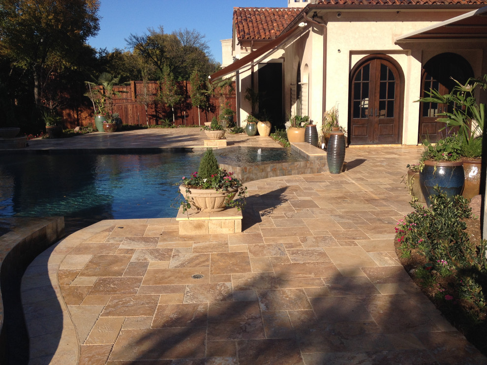 Ejemplo de piscina con fuente alargada mediterránea grande rectangular en patio trasero con adoquines de piedra natural