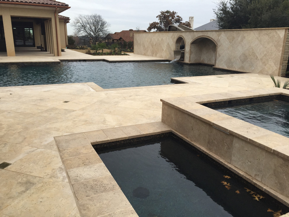 Foto di una grande piscina monocorsia chic rettangolare dietro casa con fontane e pavimentazioni in pietra naturale