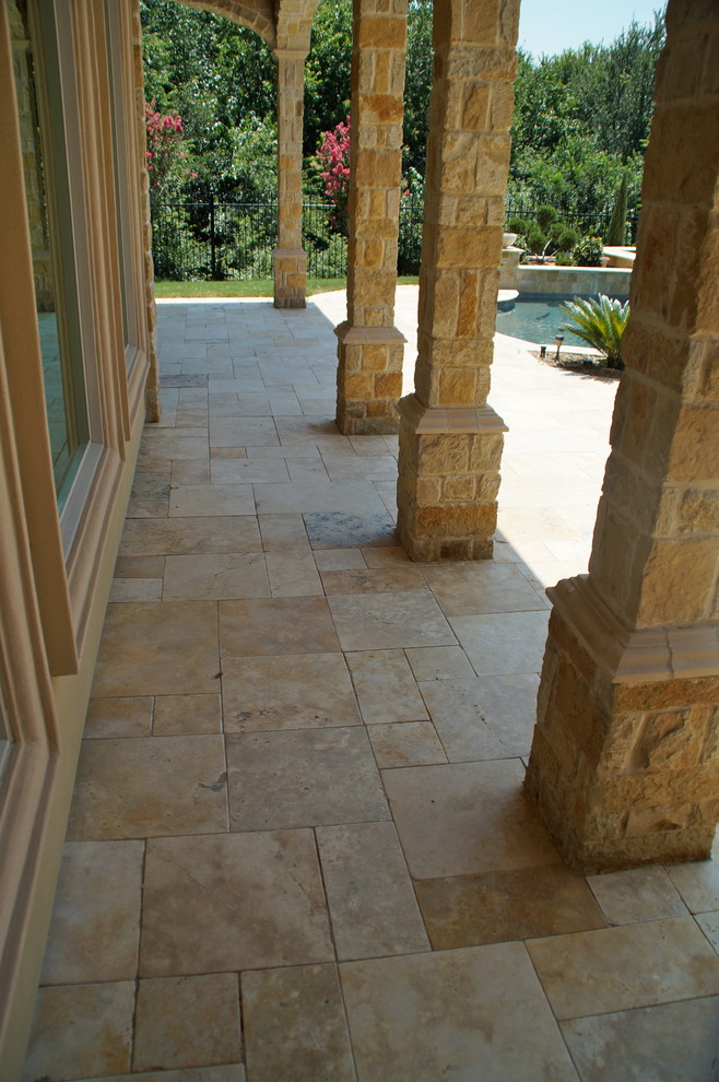 Inspiration for a large traditional back rectangular lengths swimming pool in Dallas with a water feature and natural stone paving.