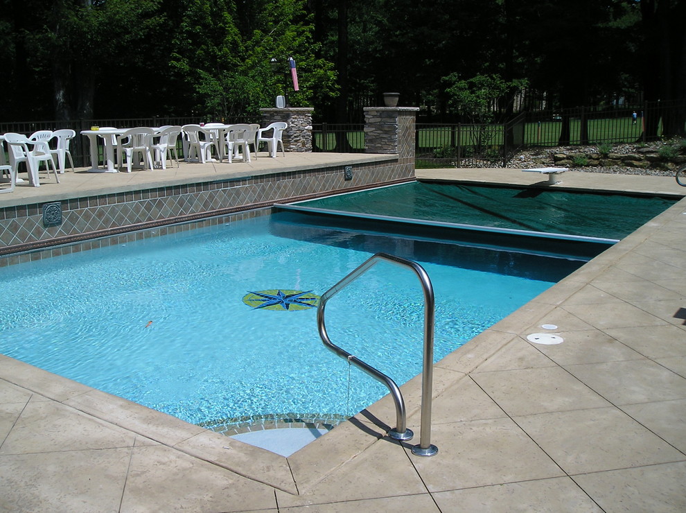 Inspiration for a medium sized classic back rectangular infinity swimming pool in Cleveland with a pool house and gravel.