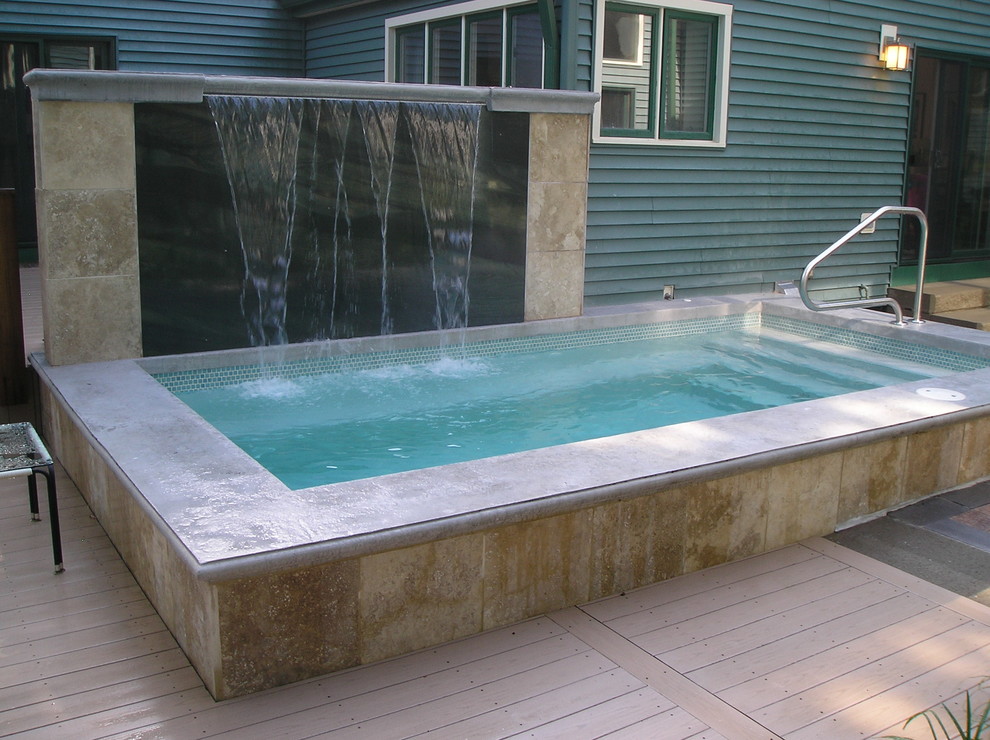 Immagine di una piscina a sfioro infinito classica personalizzata di medie dimensioni e dietro casa con una dépendance a bordo piscina e pavimentazioni in pietra naturale