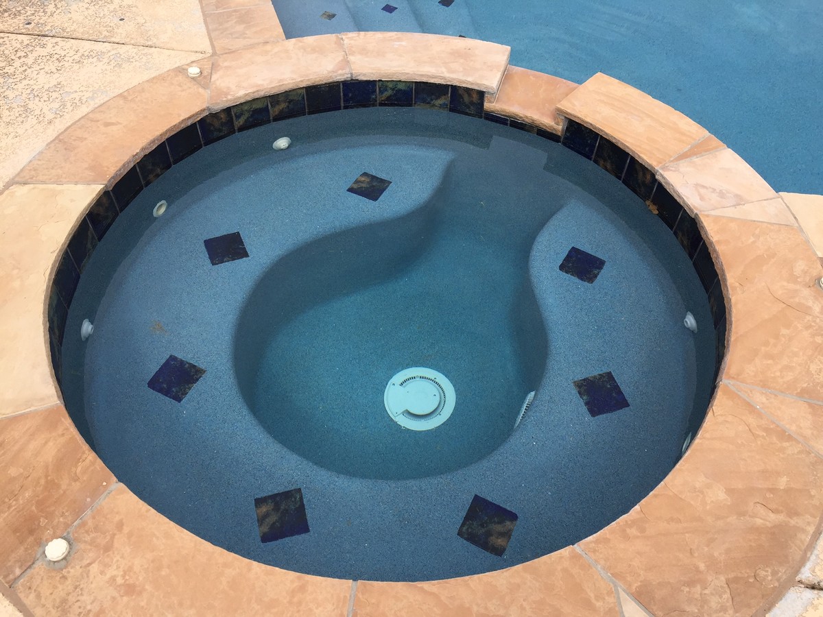 Example of an island style backyard custom-shaped natural hot tub design in Oklahoma City