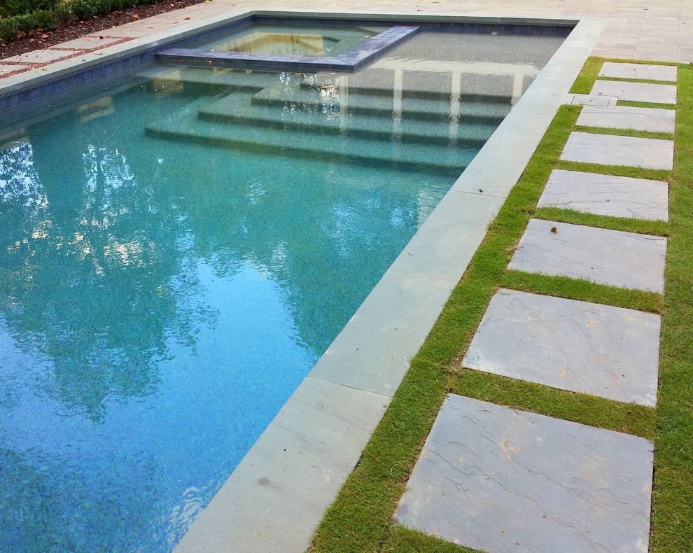 Exemple d'une petite piscine arrière tendance rectangle avec des pavés en pierre naturelle.